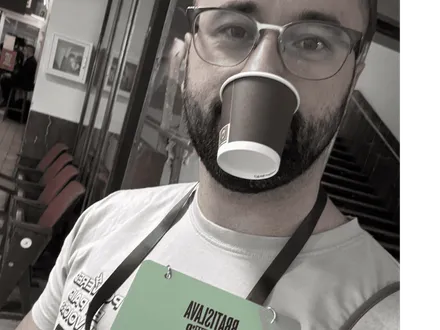 Člen tímu Lucanto s kávou a konferenčnou visačkou v Bratislave